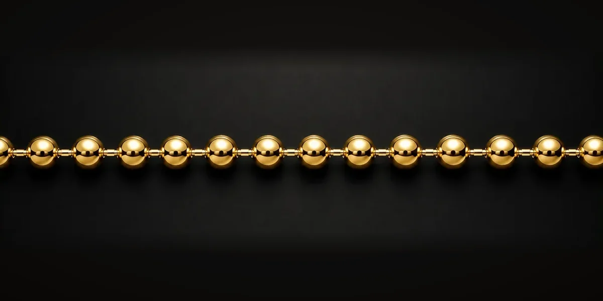 Goldene Kugelkette – Gleichmäßig runde Kugeln sind durch kurze Verbindungsstücke miteinander verbunden und bilden eine gleichmäßige, flexible Kette.