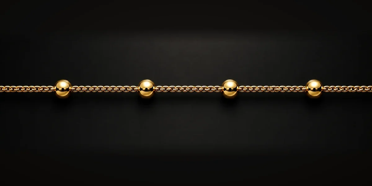 Goldene Saturnkette – Eine feine Grundkette wird in regelmäßigen Abständen durch größere Kugeln oder Elemente unterbrochen.